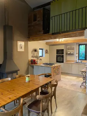 a large kitchen with a wooden table and chairs at Les terrasses des pourquiers in Gordes