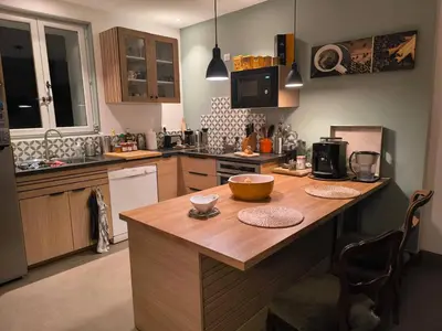 a kitchen with a wooden island in the middle at Gîte en Provence in Cavaillon