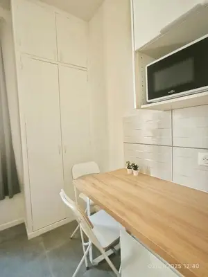 a kitchen with a wooden table and two chairs at New - studio avec clim au centre d'Aix 2eme étage in Aix-en-Provence
