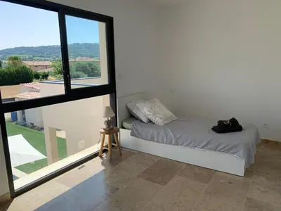 a white room with a bed and a large window at Villa MTI Ventoux in Blauvac