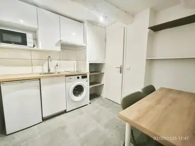 a white bedroom with a bed and a table at Studio neuf avec clim au centre d'Aix 1er étage in Aix-en-Provence