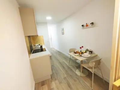 a small kitchen with a small table and a table and chairs at Studio plein centre Aix-en-Provence in Aix-en-Provence
