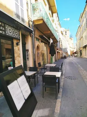 an empty street with tables and chairs on the sidewalk at Studio plein centre Aix-en-Provence in Aix-en-Provence