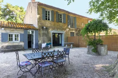 a table and chairs in front of a house at Le Gran Cabano sous les oliviers in Saint-Rémy-de-Provence