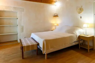 a bedroom with a bed and two tables and two lamps at Le Gran Cabano sous les oliviers in Saint-Rémy-de-Provence
