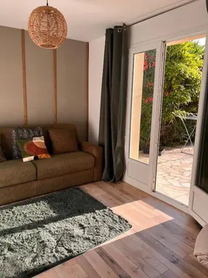 a living room with a couch and a sliding glass door at Maison 2 ch en campagne 5 mn du centre en voiture avec possibilité piscine familiale in Salon-de-Provence