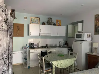 a small kitchen with a table and a microwave at Le Yodala - Lamanon in Lamanon