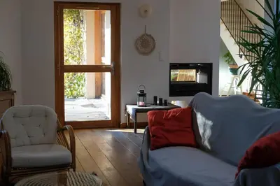 a living room with a couch and a chair and a television at La Source in Saint-Saturnin-les-Apt