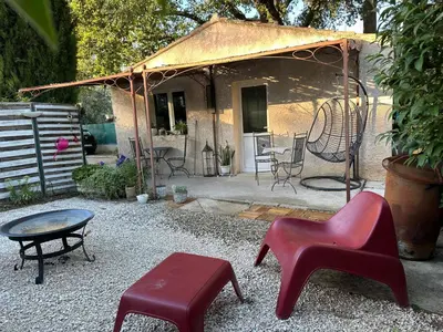 a garden with a patio with chairs and a fence at Aix Villa Theolina in Aix-en-Provence