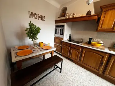 a kitchen with a table with orange plates on it at La maison aux oiseaux - Luberon in Oppède