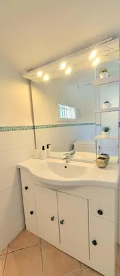 a bathroom with a white sink and a mirror at Appartement au calme à 5min du centre d'Aix-en-Provence avec terrasse vue sur jardin & parking privé in Aix-en-Provence