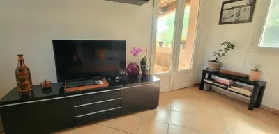 a living room with a flat screen tv on a dresser at Appartement au calme à 5min du centre d'Aix-en-Provence avec terrasse vue sur jardin & parking privé in Aix-en-Provence