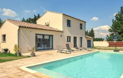 a villa with a swimming pool in front of a house at Maison Avec Piscine Privée in Monteux