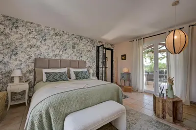 a bedroom with a bed with a green comforter at La Villa KEF - Domaine & Golf de Pont Royal in Mallemort