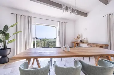 a dining room with a wooden table and chairs at Villa Sun7 in Crillon-le-Brave
