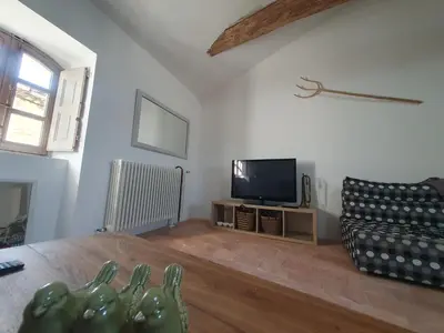 a living room with a tv and a couch at Maison Grand Rue - Vue Exceptionnelle sur le Luberon in Lauris