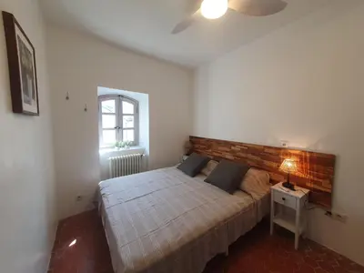 a bedroom with a large bed with a wooden headboard at Maison Grand Rue - Vue Exceptionnelle sur le Luberon in Lauris