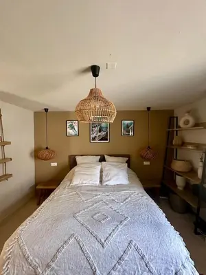 a bedroom with a large bed with a chandelier at Casa Bohemia, piscine privée proche Aix en Provence in Ventabren
