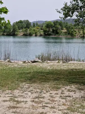 a view of a body of water with trees and grass at Mobil home en Provence - Camping 4 étoiles- 2 chambres -4 à 6 pers-clim-terrasse-TV in Cadenet