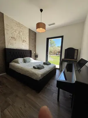 a bedroom with a bed and a table and a window at Villa Cali-Provence in Le Puy-Sainte-Réparade