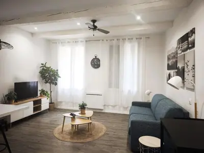 a living room with a blue couch and a tv at Aix Centre-ville in Aix-en-Provence