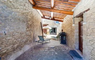 a patio with two chairs and a grill in a stone building at 3 Bedroom Stunning Home In Saignon in Saignon