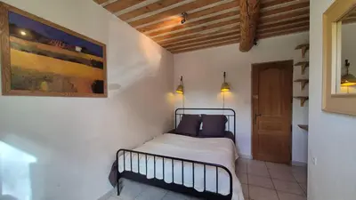 a bedroom with a bed and a painting on the wall at La maison Calavoun in Maubec