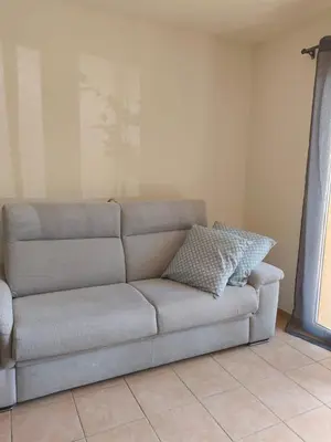 a couch sitting in a living room next to a window at Appartement idéal séjour touristique et pro in Vedène