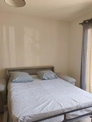 a bed with two pillows on it in a bedroom at Appartement idéal séjour touristique et pro in Vedène