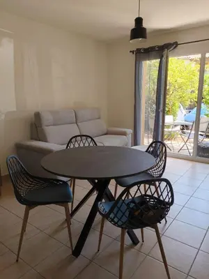 a table and chairs in a living room with a couch at Appartement idéal séjour touristique et pro in Vedène