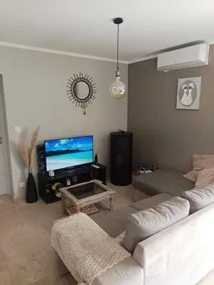 a living room with a couch and a flat screen tv at Villa KAMARO in LʼIsle-sur-la-Sorgue