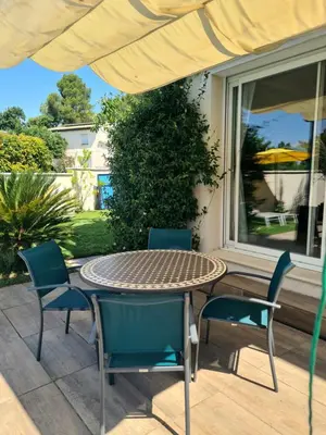 a patio with a table and chairs and a window at Villa KAMARO in LʼIsle-sur-la-Sorgue