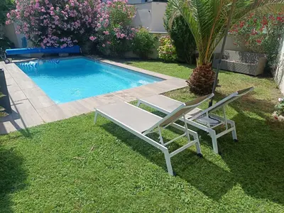 a pair of chairs and a swimming pool at Villa KAMARO in LʼIsle-sur-la-Sorgue
