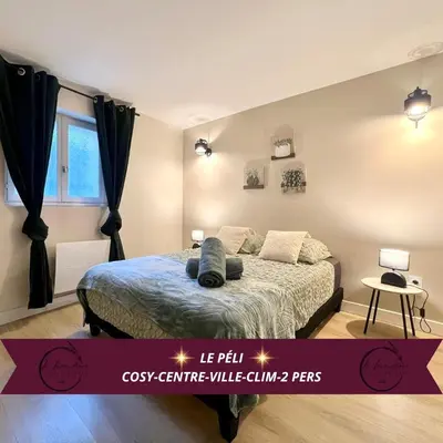 a bedroom with a bed with a blue comforter at Le Péli - Cosy, Centre-ville, CLIM, 2 personnes in Pélissanne