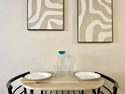 a wooden table with two plates and a glass bottle at Le Péli - Cosy, Centre-ville, CLIM, 2 personnes in Pélissanne