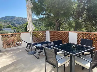 a patio with a table and chairs and an umbrella at Appartement T2 dans le Luberon in Cavaillon