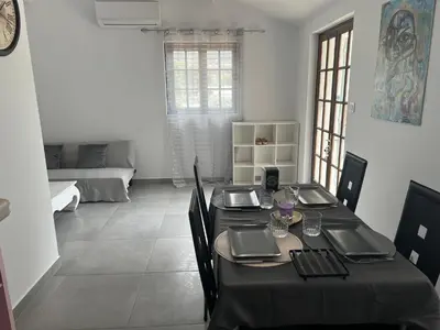 a dining room with a table and a living room at Appartement T2 dans le Luberon in Cavaillon