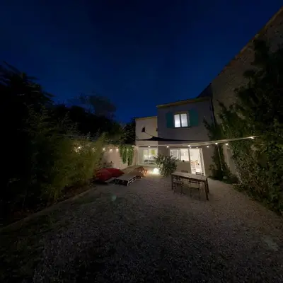 a house lit up at night with a bench in front of it at Chez Pascal et Marion in La Tour-dʼAigues
