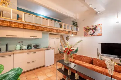 a living room with a couch and a kitchen at Studio Mezzanine Cosy in Aix-en-Provence