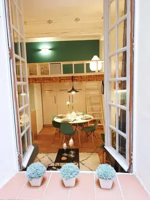 a room with a table and chairs and a room with windows at Studio Mezzanine Cosy in Aix-en-Provence