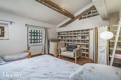 a bedroom with a bed and a chair and a book shelf at Parenthèse en Luberon in Rustrel