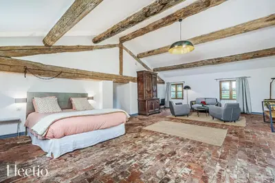a bedroom with a bed and a living room at Parenthèse en Luberon in Rustrel