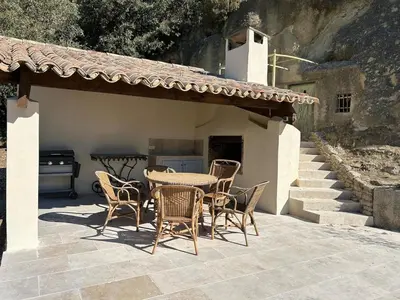 a patio with a table and chairs and a grill at Bastidon provençal entièrement rénové et climatisé in Vaugines