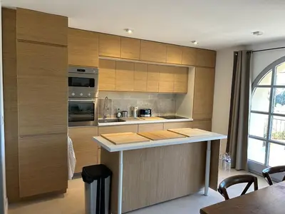 a kitchen with wooden cabinets and a counter top at Bastidon provençal entièrement rénové et climatisé in Vaugines