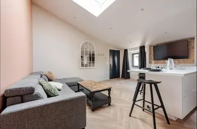 a living room with a couch and a kitchen at Le fort 7 Appart centre ville in LʼIsle-sur-la-Sorgue