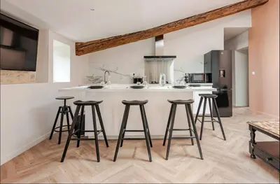 a kitchen with a counter with stools in it at Le fort 7 Appart centre ville in LʼIsle-sur-la-Sorgue