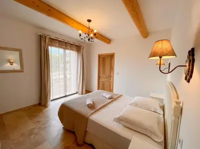 a bedroom with a bed and a large window at Maison de charme 4 étoiles - superbe vue et bassin-piscine privé in Rustrel