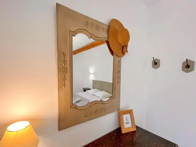 a mirror on a wall with a bed in a room at Maison de charme 4 étoiles - superbe vue et bassin-piscine privé in Rustrel