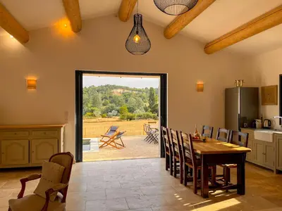 a kitchen with a table and chairs and a patio at Maison de charme 4 étoiles - superbe vue et bassin-piscine privé in Rustrel