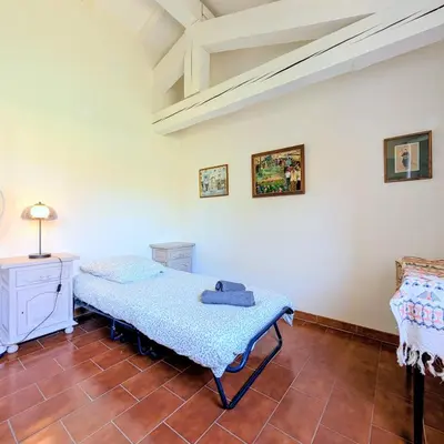 a bedroom with a bed and a red wall at L'Oliveraie - Maison Familiale avec Piscine privée - Clim - Wifi - 4 Chambres - 3 Salle de Bains in Jouques